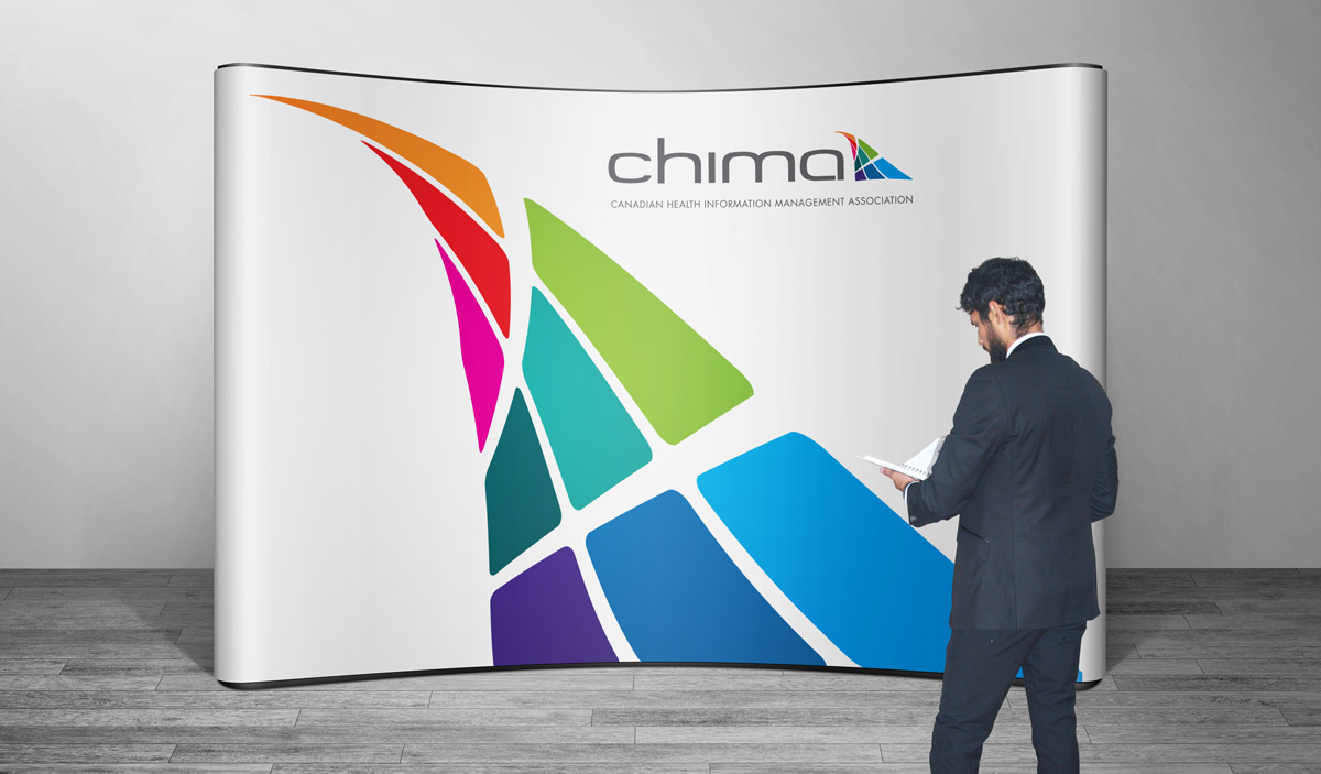 Man looking at a booklet, while standing in front of CHIMA's trade show booth.