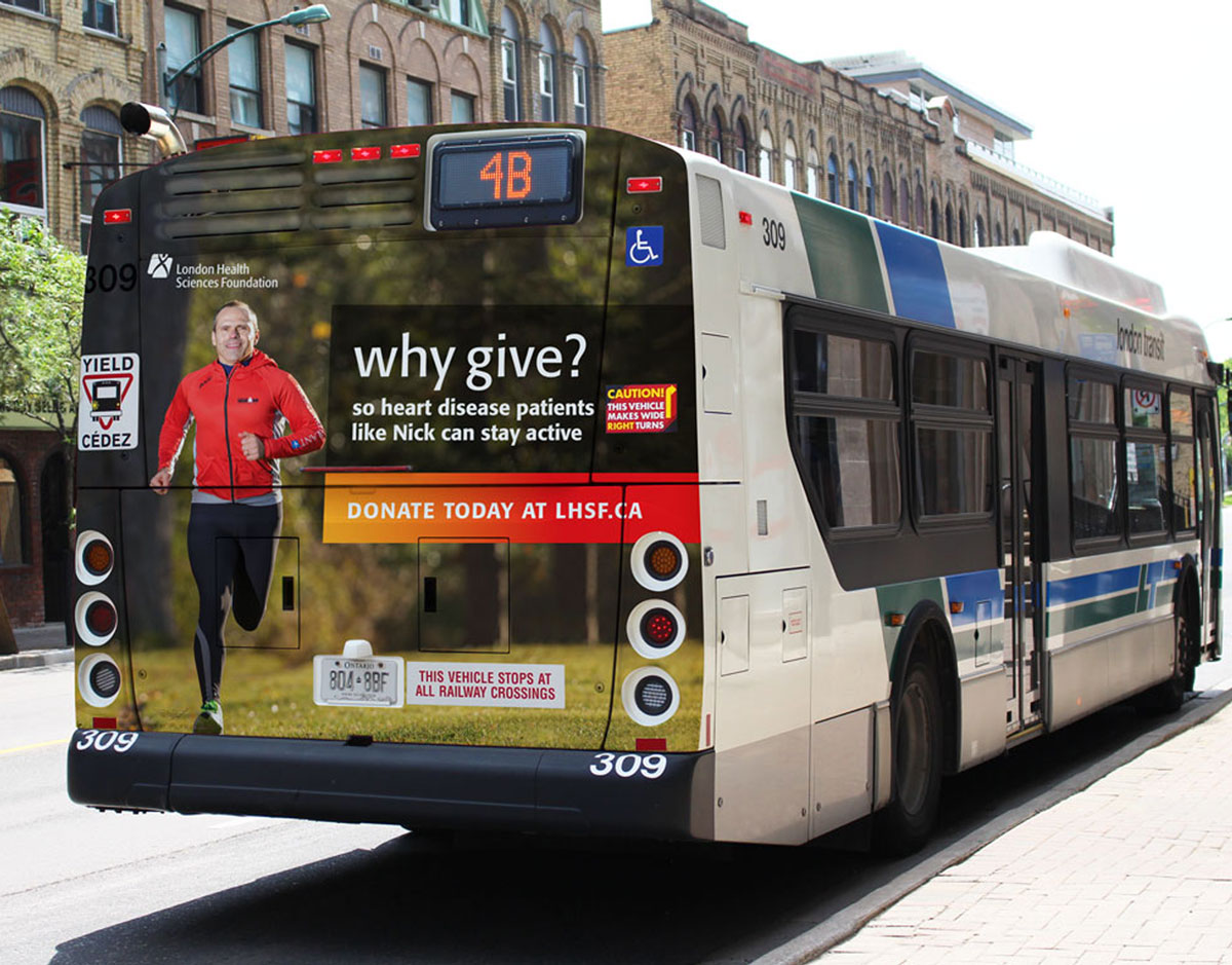 Why Give bus back advertisement on a London Transit bus driving down the street.